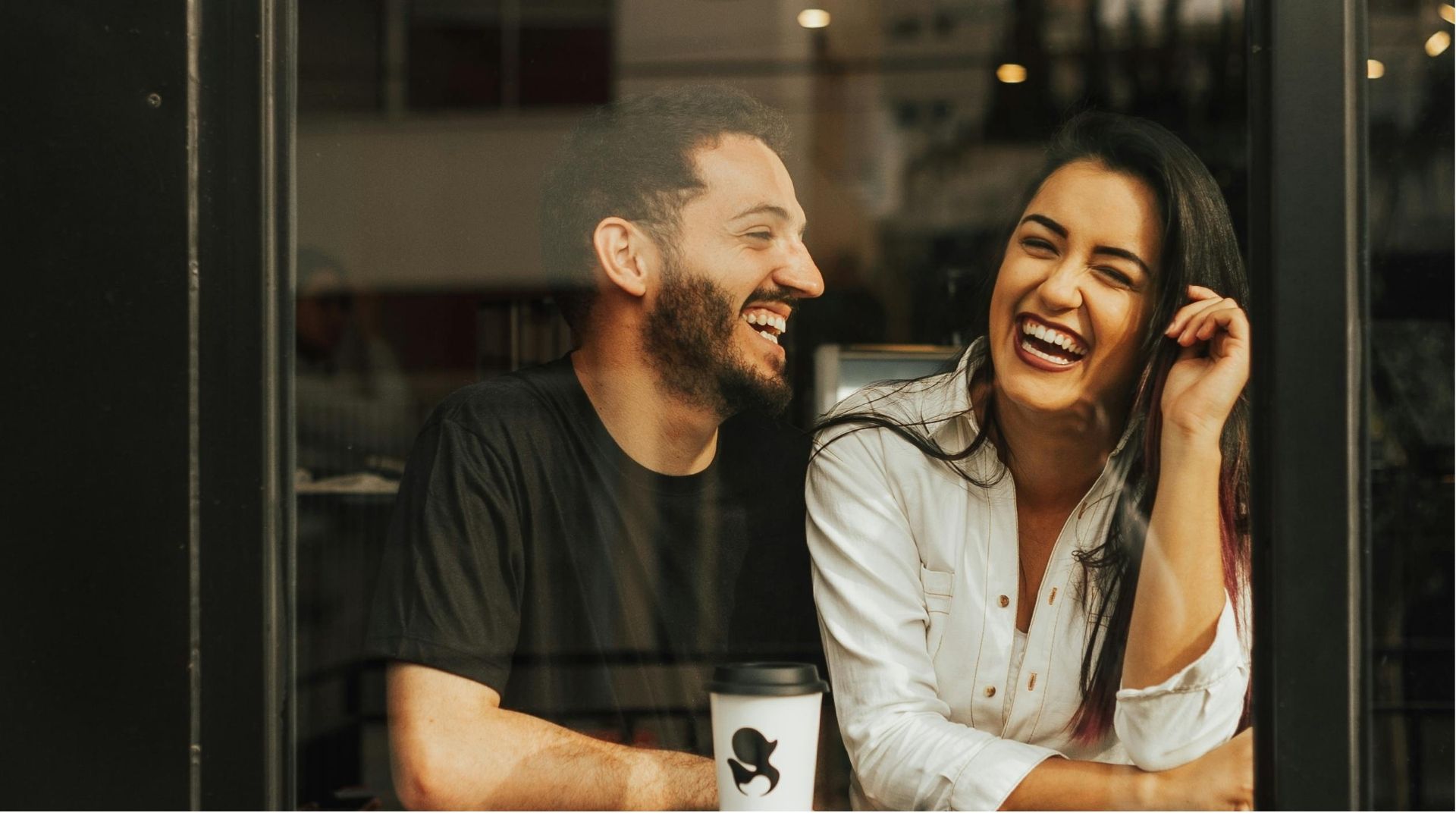 A couple laughing together at a café